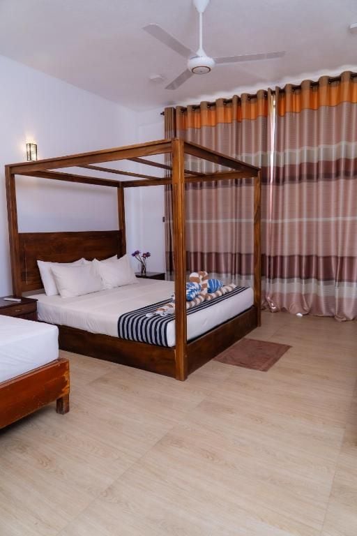Una camera da letto con un letto a baldacchino, un comodino e una ventola a soffitto.