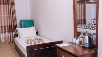 Un dormitorio con una cama, un aparador de madera, un espejo y una mesita de noche.