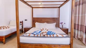 A four-poster bed with a wooden frame, two bedside tables, and a nightstand.
