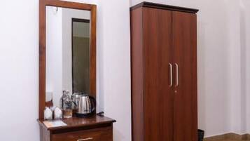 Una habitación con un armario de madera, un espejo y un pequeño aparador de madera.