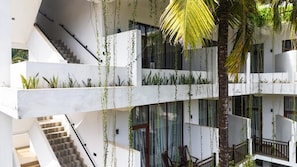 A multi-level interior with a staircase, glass railings, and indoor plants.