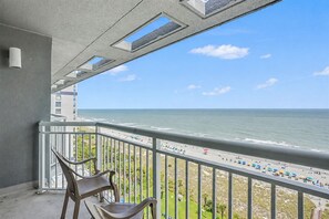 Ein Balkon mit Blick auf Strand und Meer.