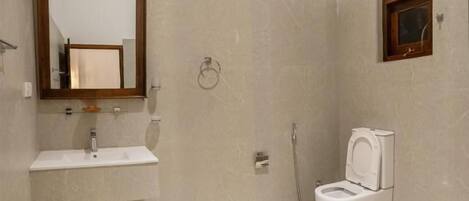 Een badkamer met een wastafel, spiegel, toilet en douche.