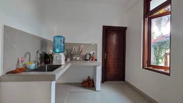 Una cucina compatta con dispenser per acqua, lavello e una finestra vista.