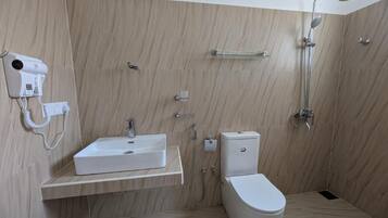 A modern bathroom with a white sink, toilet, and shower.