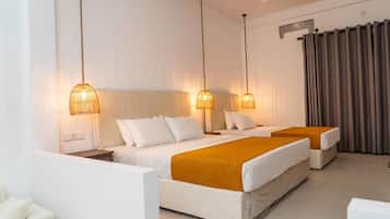 Una camera d'albergo con due letti, un divano e una ventola a soffitto.