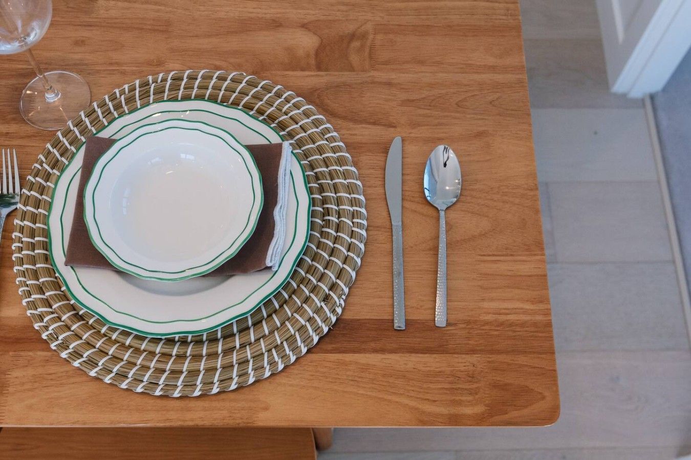 Una mesa de comedor con platos, cubiertos y una servilleta doblada.