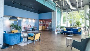 A modern interior with a blue and white color scheme, wooden flooring, and a mix of seating areas including sofas and chairs. - Light-Filled Living in Salford (Salford)