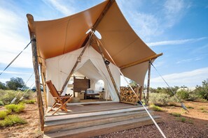 A tent with a wooden deck, a dining table, and chairs. - Under Canvas Santa Fe (Lamy)