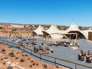 A desert resort with teepees, outdoor seating, and a gravel path. - Under Canvas Santa Fe (Lamy)