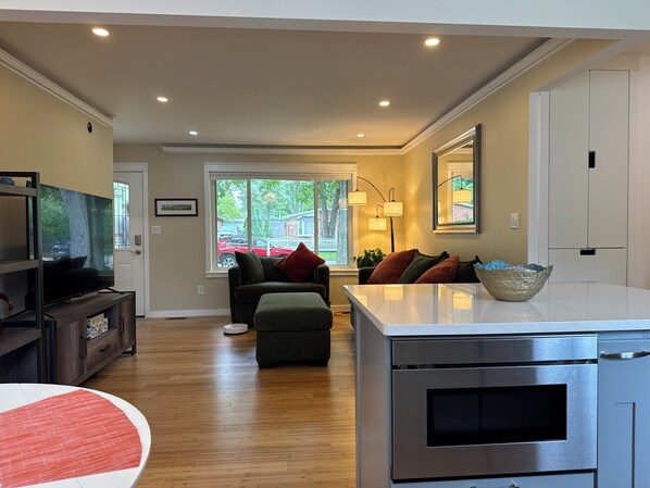 A modern kitchen with a built-in oven and a dining area with a table and chairs.