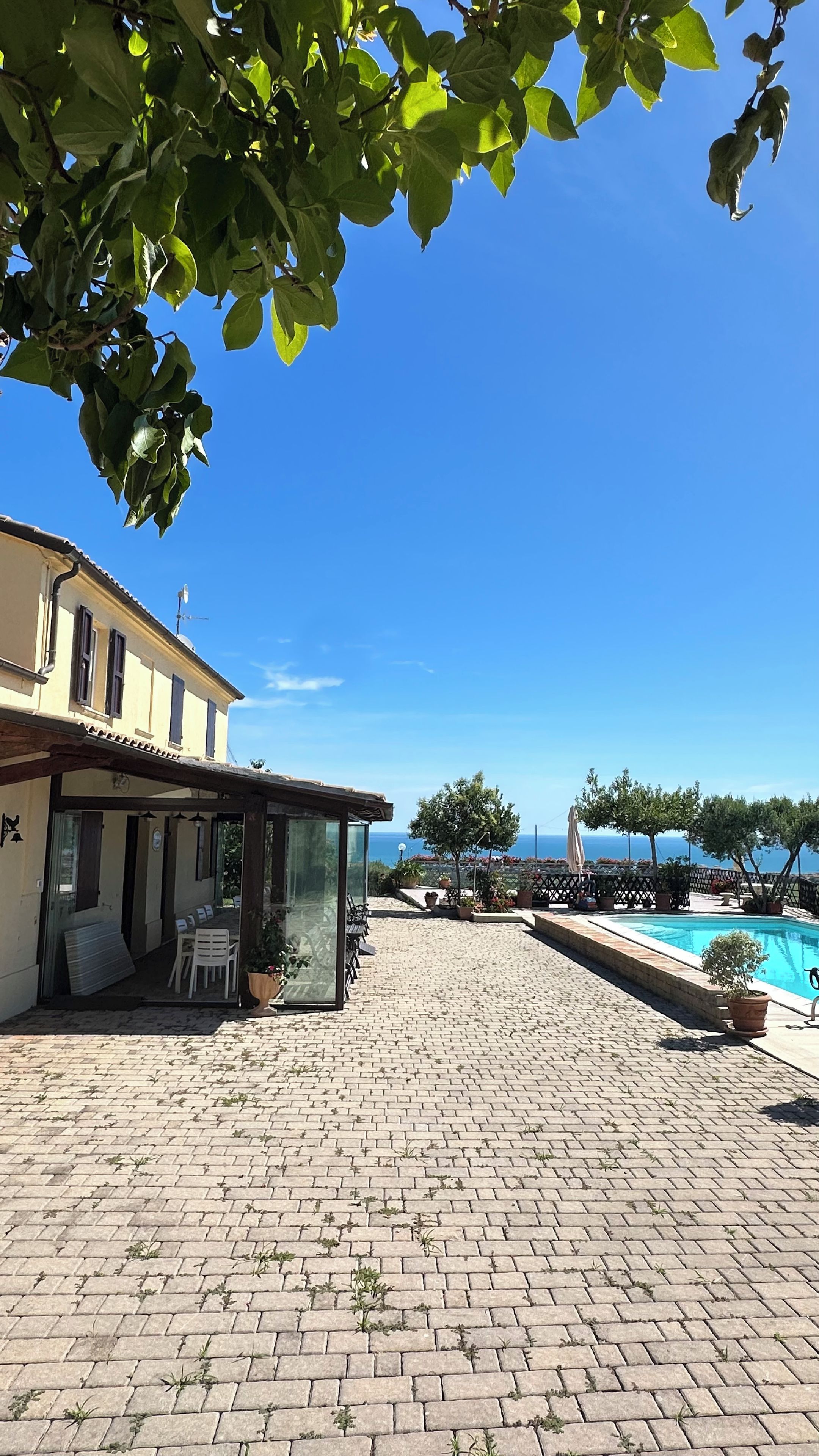 Une cour avec une piscine, un espace salon extérieur et une vue sur la mer.
