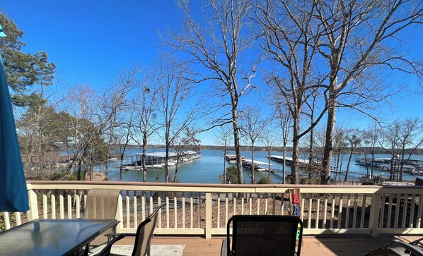 A deck with a view of a lake, docked boats, and a sign reading 'LA'.