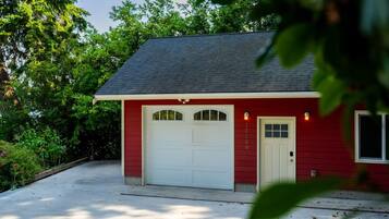 A red garage with a white door, a driveway, and a house number 15130.