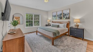 A bedroom with a bed, bedside tables, a TV, a window, and a painting. - Soulful Summit at Forest Ridge- Pools & Hot Tub (Lincoln)