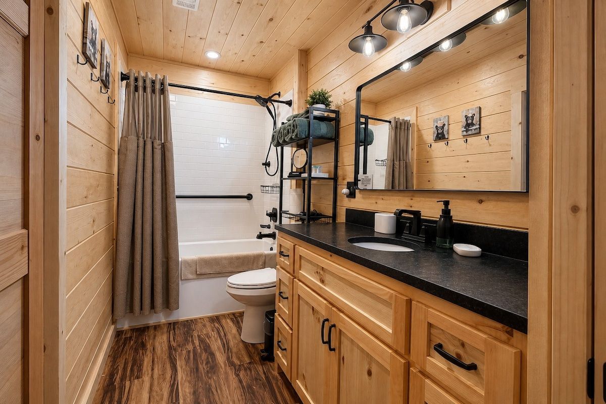 A wooden-paneled bathroom with a bathtub, toilet, and sink.