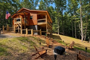 A cabin with a porch, outdoor seating, and a flag. - NEW CABIN! - MawMaw Bear's Nook -King Bed-Dog Yard (Murphy)