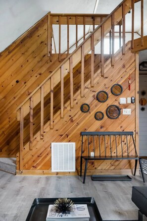 A wooden staircase with a black metal railing, a white vent, and a black bench at the bottom. - The Pine Haven - 8 Min to Kalahari - Hot Tub & Fire Pit (Long Pond)