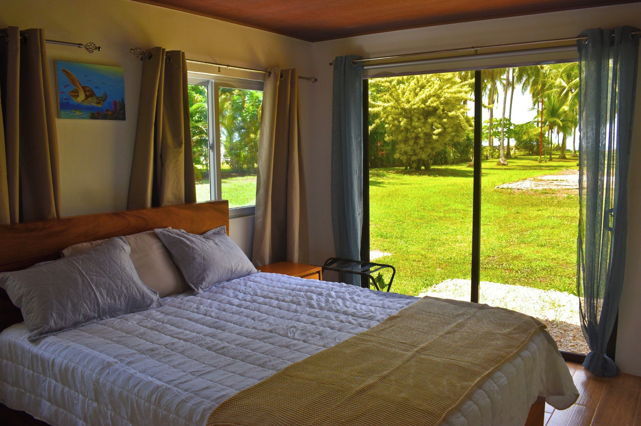 Bedroom with sliding doors opening to the garden and palms