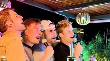 A group of people singing outdoors at night.