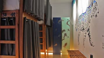 Un pasillo con taquillas, un banco y una pared con un diseño.