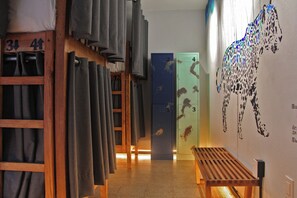 Un pasillo con taquillas, un banco y una pared con un diseño.