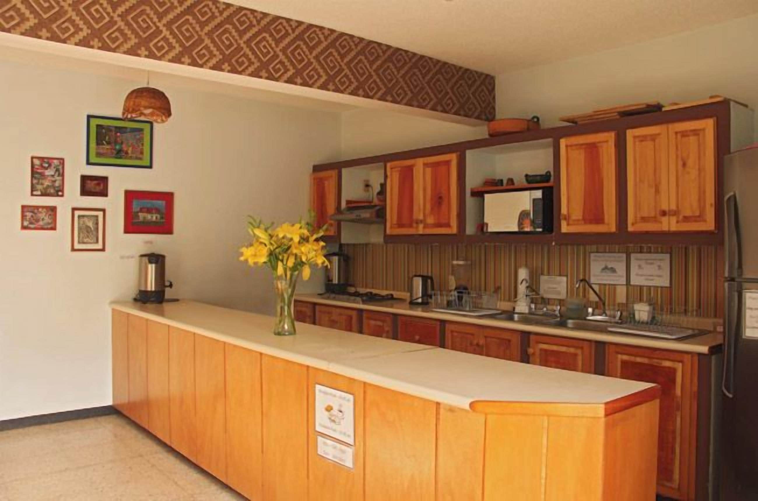 A kitchen with wooden cabinets, a countertop, and a refrigerator.