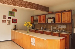 Una cocina con armarios de madera, una encimera y un refrigerador.