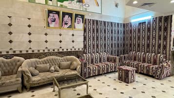 A lobby with a patterned wall, a sofa set, and a coffee table.