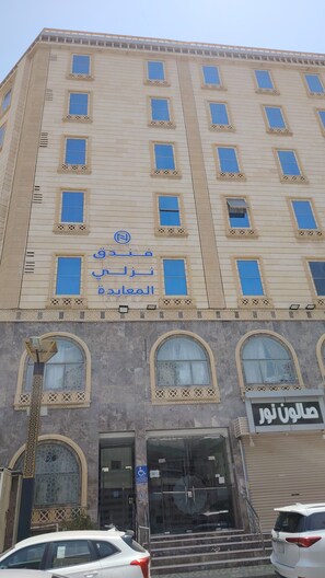 Un edifici de diversos pisos amb façana beix, nombroses finestres i un rètol que indica que és un hotel.