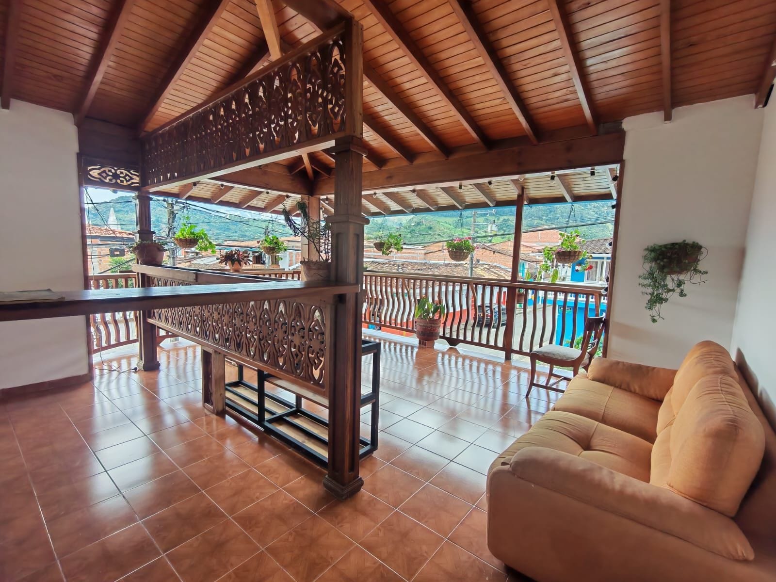 Ein geräumiger Balkon mit Hollerüstung, einer gepolsterten Couch und Topfpflanzen.