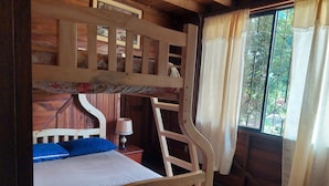 A bunk bed with a wooden frame, a bedside table with a lamp, and a window with curtains. - Your Amazonian retreat, private pool, and nature (Tena)