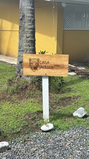 Un panneau en bois orné d’un motif de jaguar et portant l’inscription « PARCING CASA JAGUAR », indiquant une zone de stationnement.