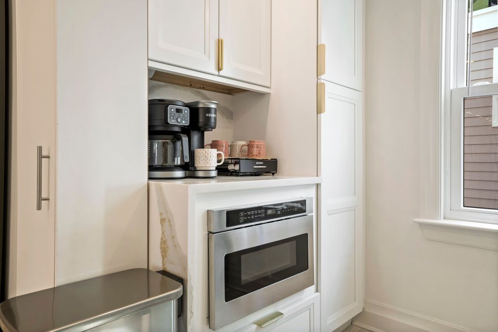 A kitchen with a built-in oven and coffee maker.