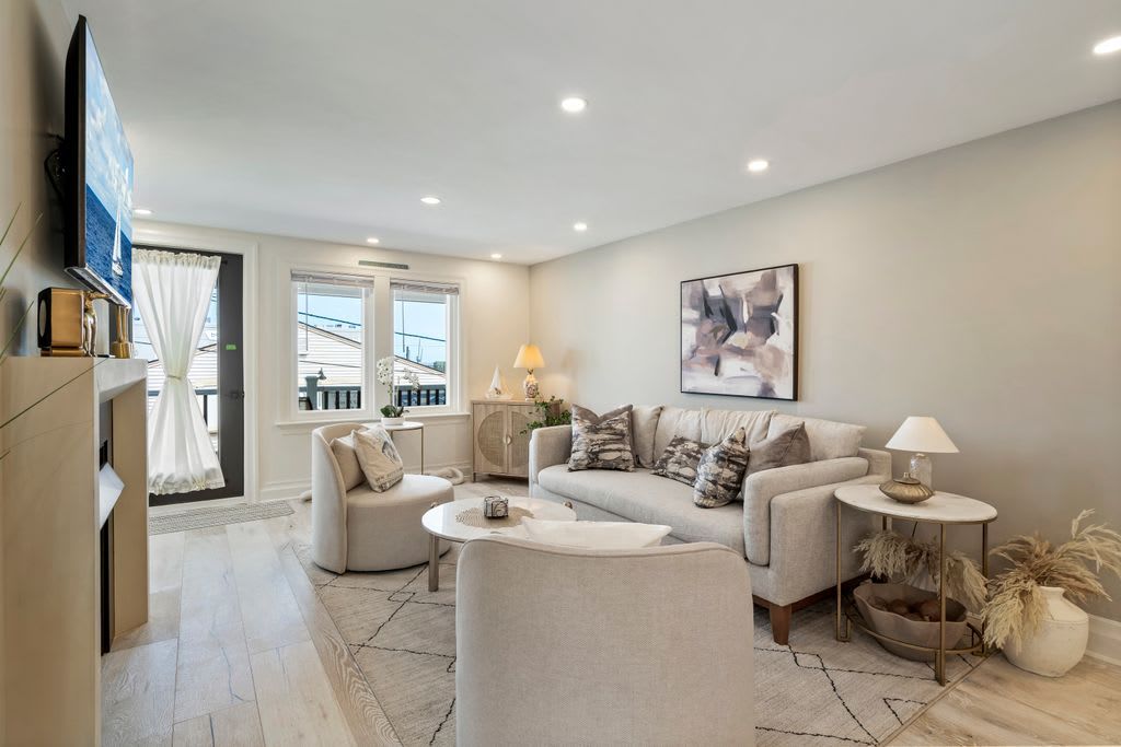 A modern living room with a sofa set, a coffee table, and a TV mounted on the wall.
