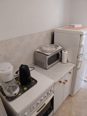 A compact kitchen with a Bosch coffee maker, a microwave, and a compact refrigerator. - Kuča na rjeci s velikim vrtom I pogledom na planine,3km od mora - Split 10km. (Žrnovnica)