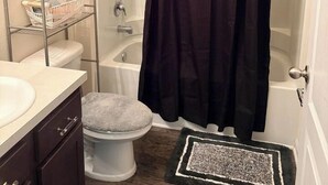 Et badeværelse med brusebad, toilet og vask.
