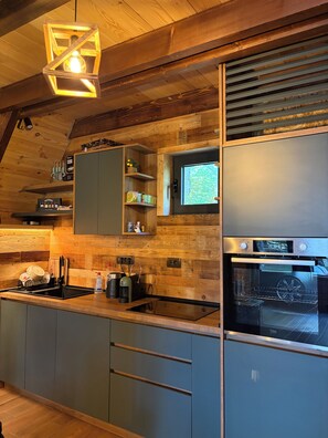 Une cuisine moderne avec des meubles en bois, un four encastré et une fenêtre.