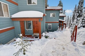A two-story building with a snow-covered entrance and a visible mailbox. - Big White Ski-In/Ski-Out Townhome | Private Hot Tub + Mountain Views (Kootenay Boundary E / West Bo*)