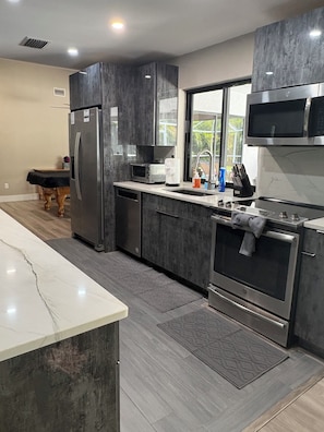 A modern kitchen with a stainless steel refrigerator, microwave, and oven. -  Welcome to The Tropics (Cape Coral)