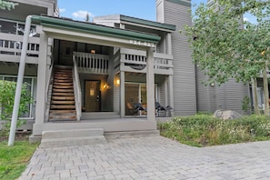 A two-story building with a covered porch, a staircase, and a paved driveway. - 2BR Condo for 6 w Shared Hot Tub, Near Mtn & Lakes (Mammoth Lakes)