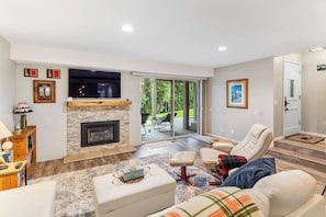 A modern living room with a fireplace, comfortable seating, and a view of the outdoors. - 2BR Condo for 6 w Shared Hot Tub, Near Mtn & Lakes (Mammoth Lakes)