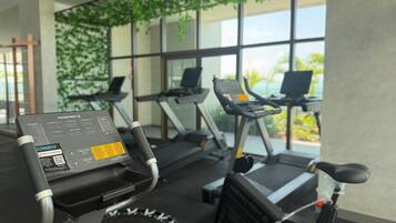 Un gimnasio con cintas de correr y una bicicleta estática, que incluye un panel de control con datos de entrenamiento.