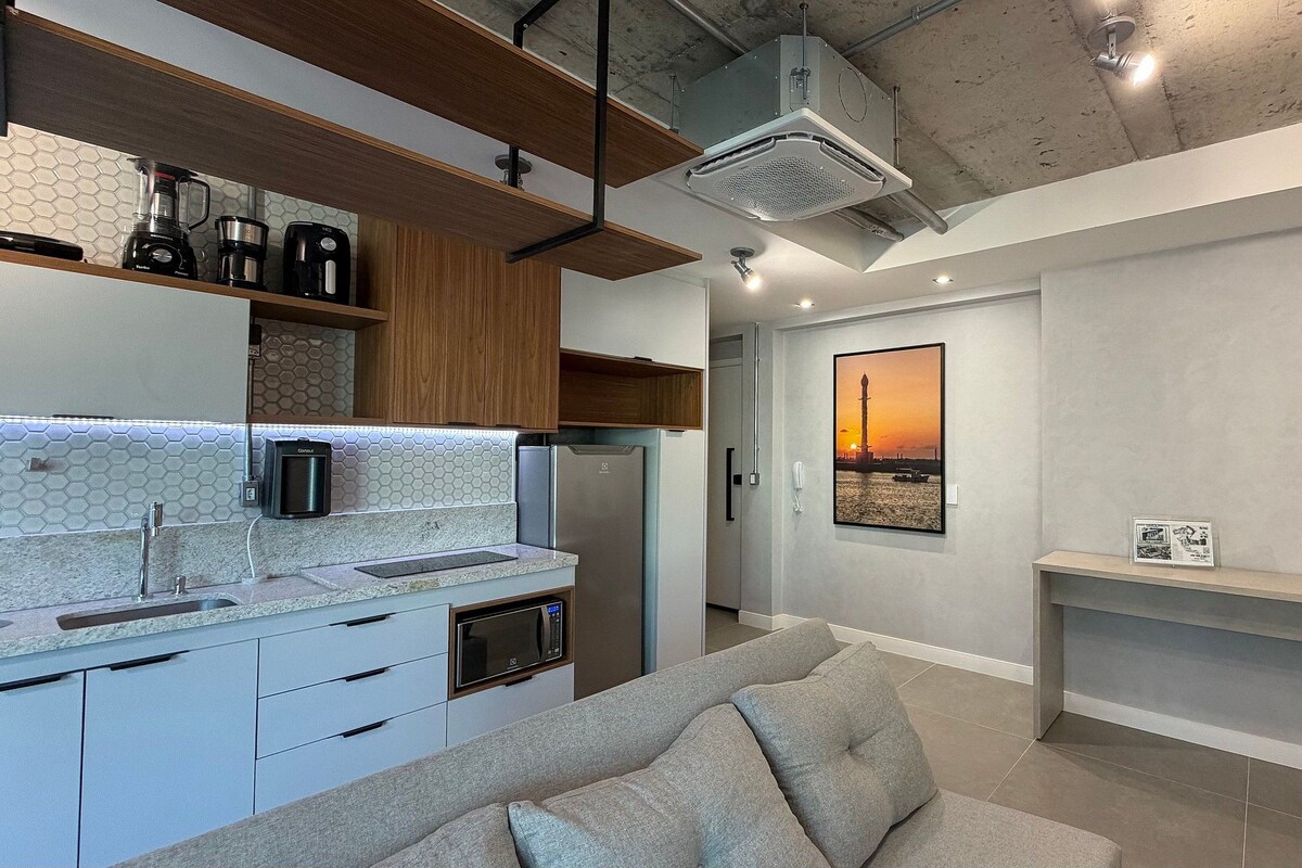 A modern kitchen with a built-in oven, microwave, and coffee maker.