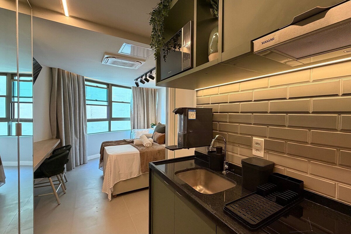 A modern kitchen with a built-in oven, a coffee machine, and a sink.