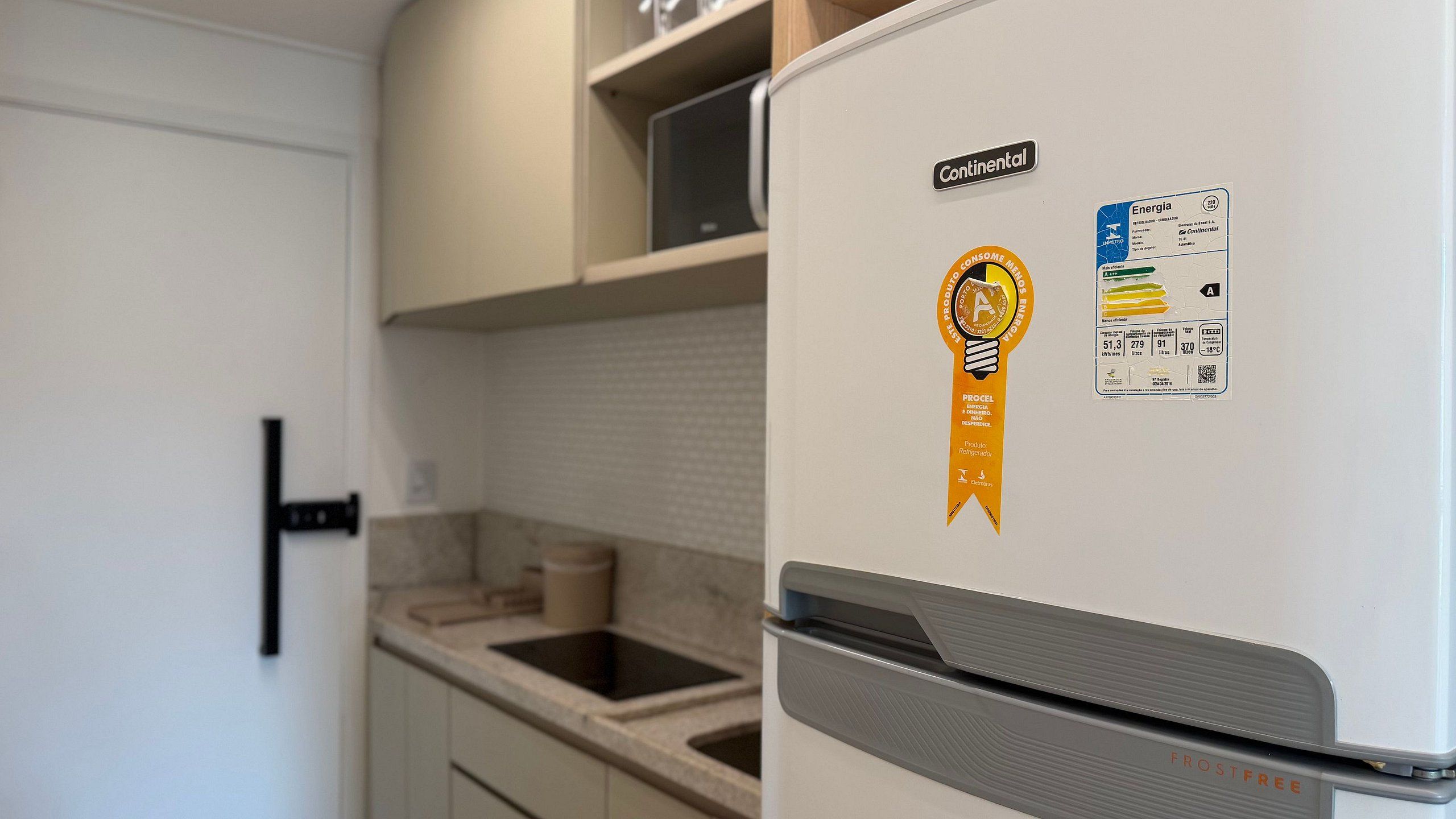 Una cocina con un refrigerador blanco, un lavamanos y armarios.