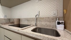 A modern kitchen with granite countertops, stainless steel sinks, and a built-in dishwasher.