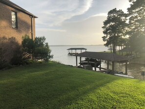 A grassy area with a dock extending into a body of water, a brick building, and a gazebo. - 4-bedroom house with AC in charming Crosby (Crosby)