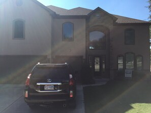 A black Lexus SUV parked in front of a two-story house with a garage. - 4-bedroom house with AC in charming Crosby (Crosby)