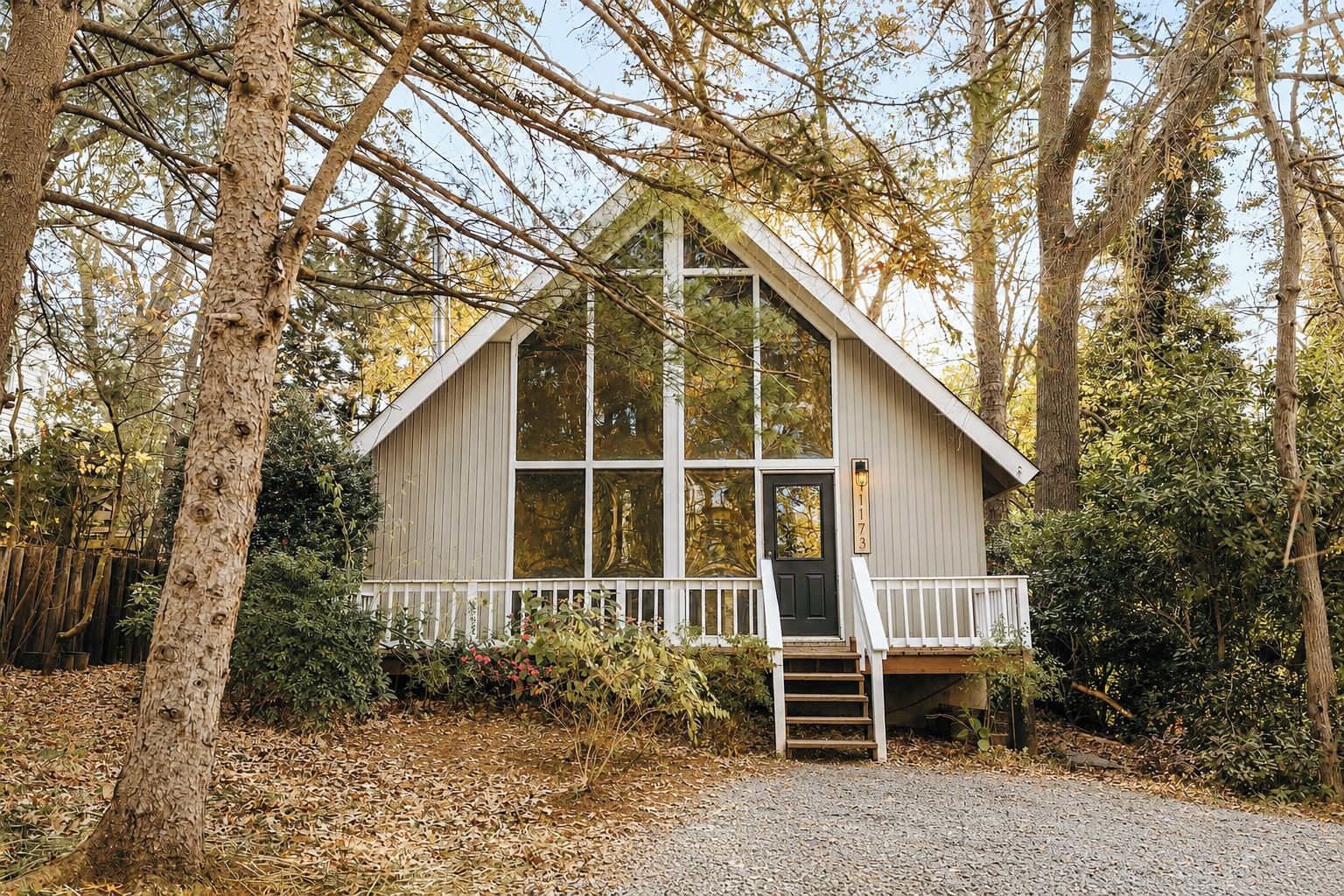 A cabin with a front porch, a door, and a number sign.